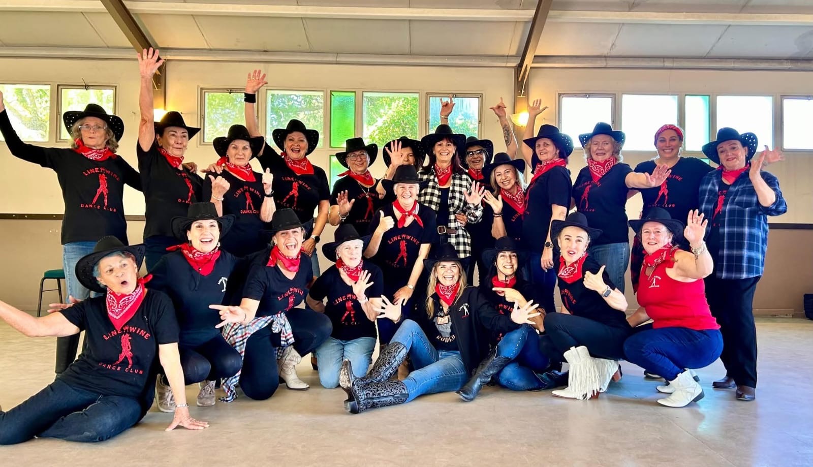 Line & Wine members posing in cowboy hats and red bandanas at a themed gathering