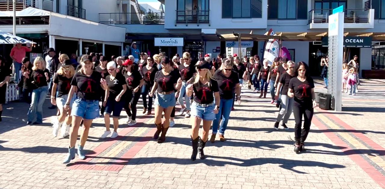 The Line & Wine community line dancing together outdoors